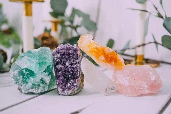 Assorted healing crystals placed on a wellness treatment table with soft natural light.