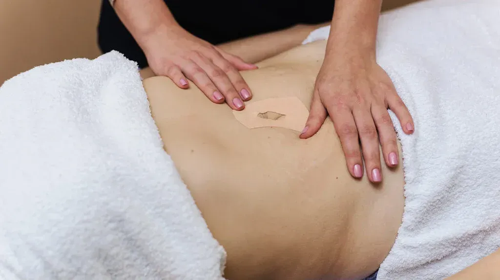 A close-up of LifeWave patches being applied to a person’s shoulder with soft light illuminating the skin.