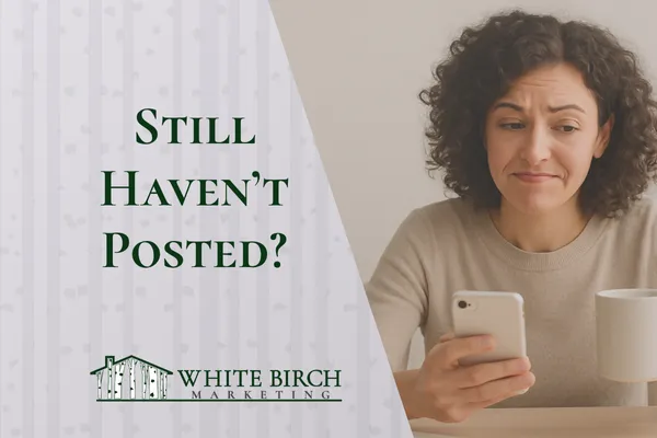 Real estate agent at desk holding coffee, looking at phone with slight frustration — blog header image about social media consistency"
