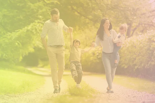 Smiling family walking hand in hand on a sunny path, representing calm connection and joy in family life.
