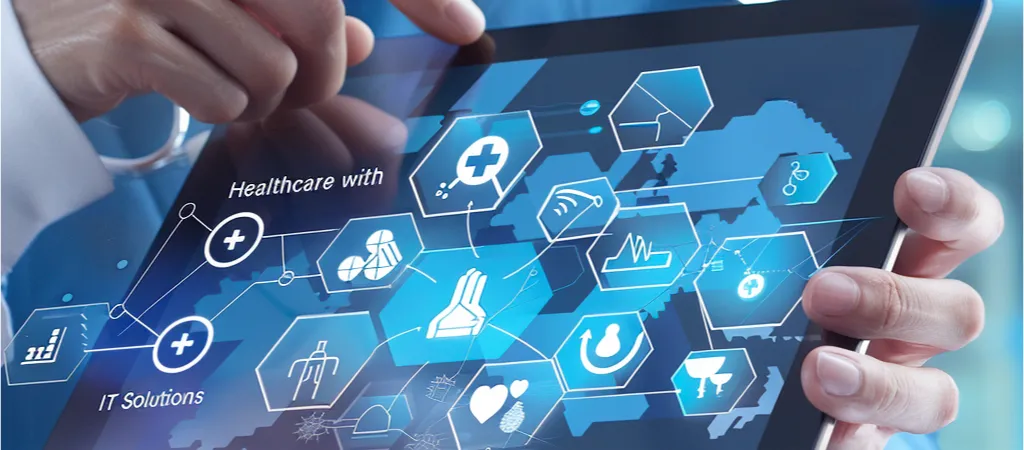 Alt Text: "Close-up view of a person's hand holding a tablet displaying a dynamic and interactive digital interface with icons related to healthcare and IT solutions, such as a stethoscope, heart rate monitor, medical bag, and network connectivity symbols, overlaid on a futuristic blue map graphic, symbolizing the integration of modern technology in healthcare management