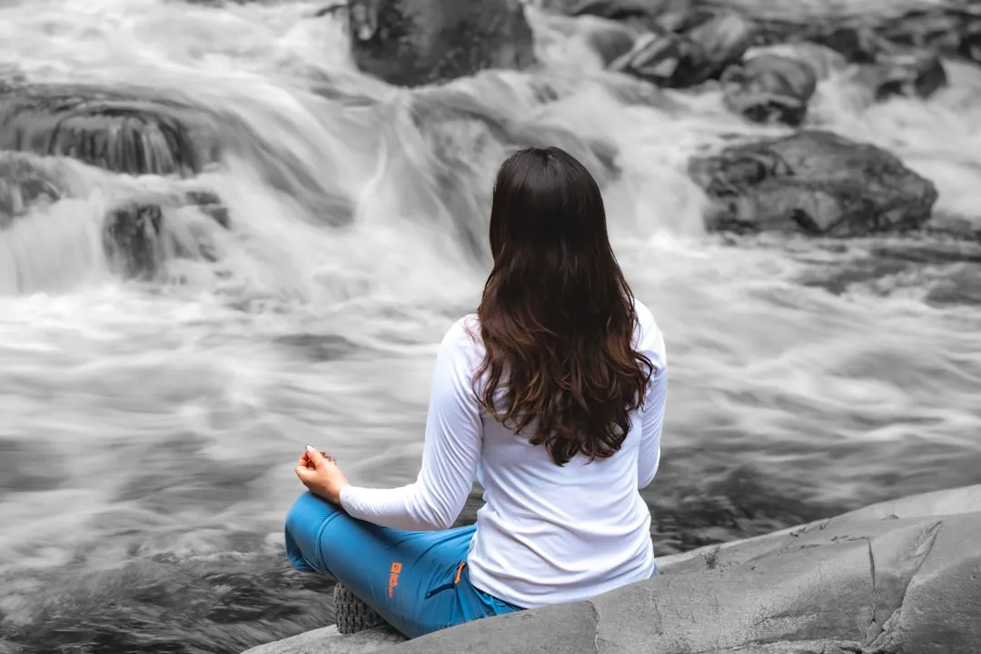 Woman sitting on a rock looking at the rapids