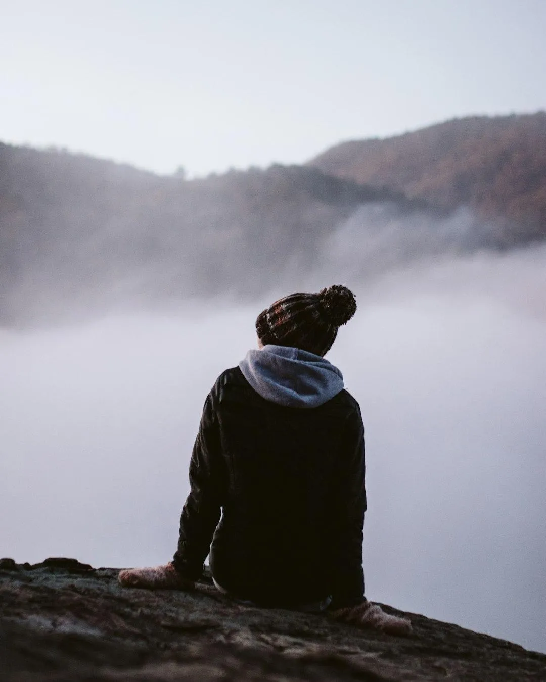 Woman reflecting quietly while sitting and look at the mountain mist