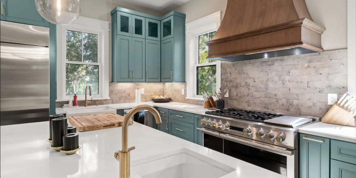 Modern kitchen with teal cabinets, wood range hood, and white quartz island in Oklahoma home