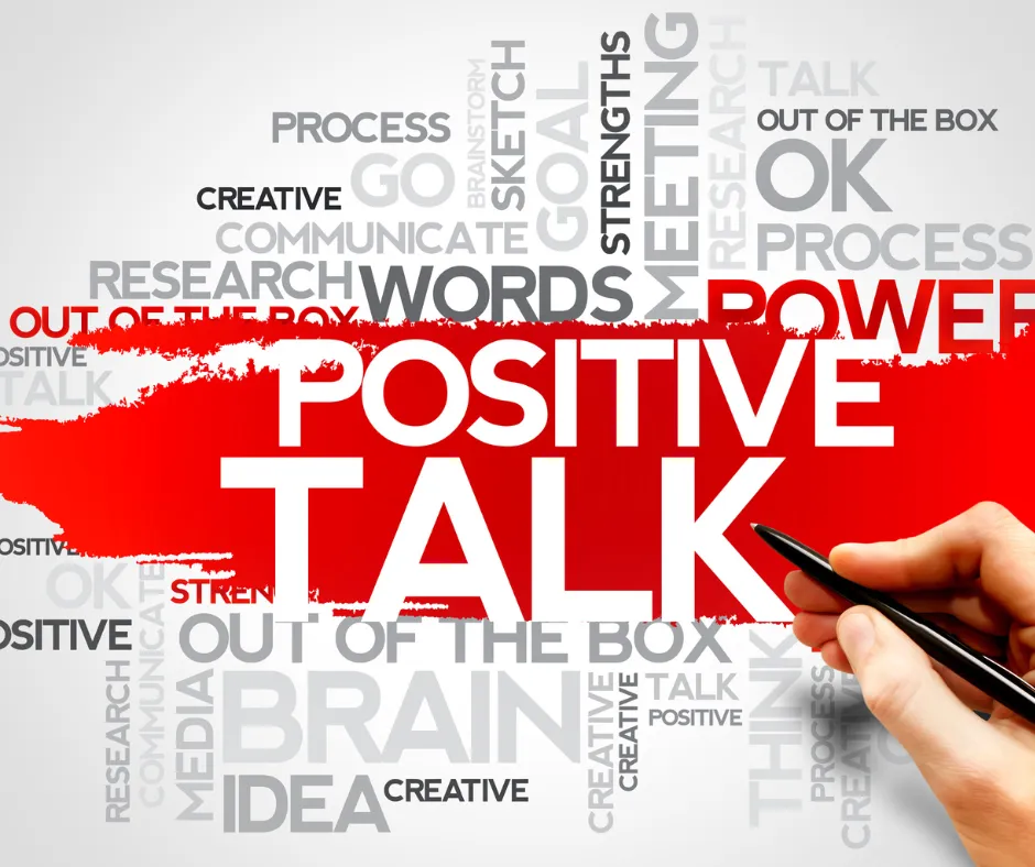 Graphic image featuring the words 'Positive Talk' in bold red with a background of various motivational terms like 'Strengths,' 'Creative,' 'Brainstorm,' and 'Out of the Box' in grayscale. A hand holding a pen appears on the right, symbolizing the power of words and self-talk in personal development.