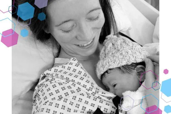 Emma, a woman after a c-section lying in a hospital bed smiling down to her newborn son on her chest