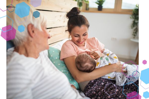 Grandmother sitting beside her adult daughter, who is breastfeeding her newborn in a bright, modern bedroom — illustrating the warmth and support discussed in the Grandparents Course by CubCare, which helps grandparents understand modern maternity care and postnatal recovery.
