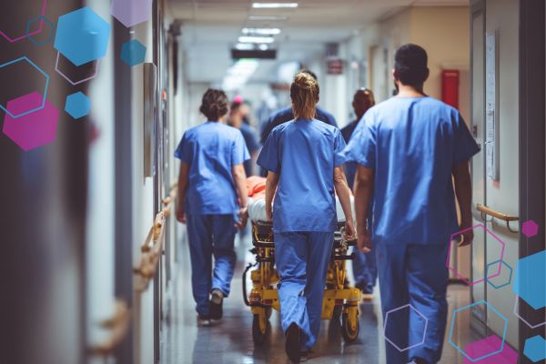 Hospital maternity staff walking together down a corridor with a patient on a trolley, representing the different professionals involved in pregnancy and birth care and the importance of understanding each role.
