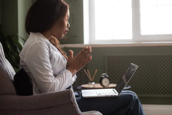 A laptop screen showing a therapist talking during a virtual therapy session.