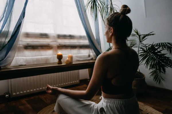 A flat lay of a journal, tea, and a candle on a cozy table, symbolizing self-care and relaxation.
