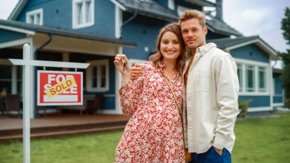 happy homeowner standing in front of sold house