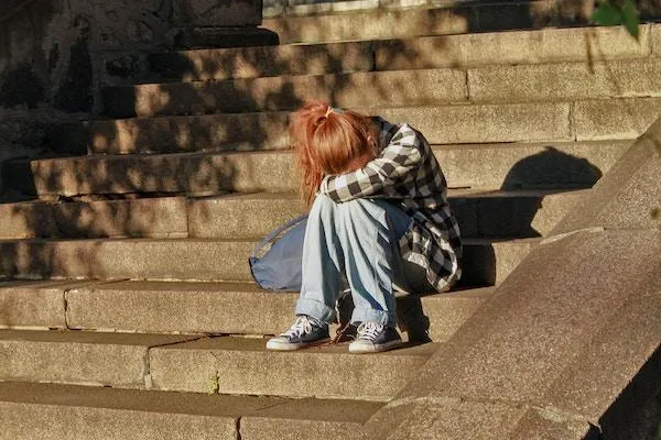 Teenage girl student upset sitting on stairs
