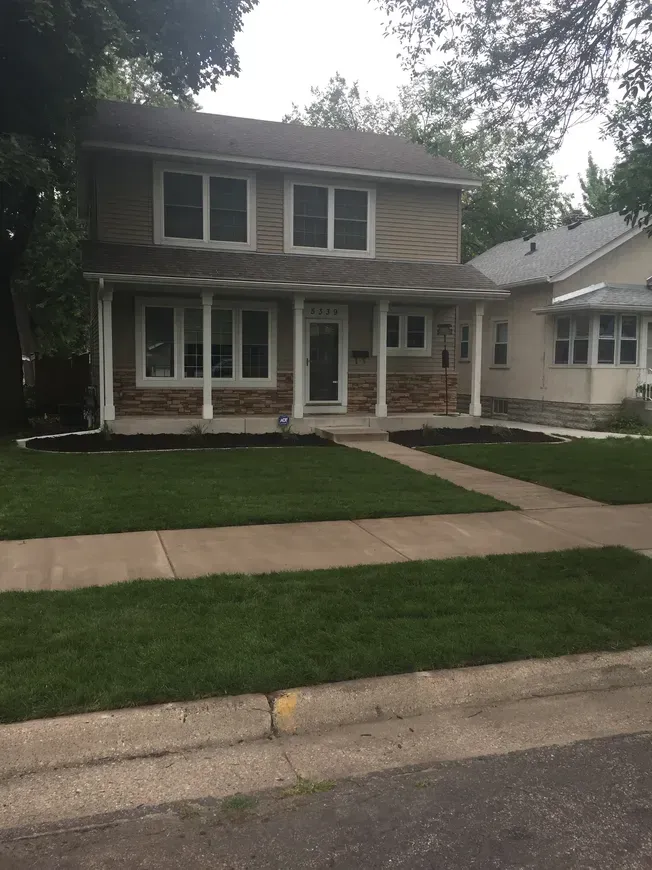 Commercial landscaping in Cambridge, MN, featuring lush lawns and clean sidewalk 