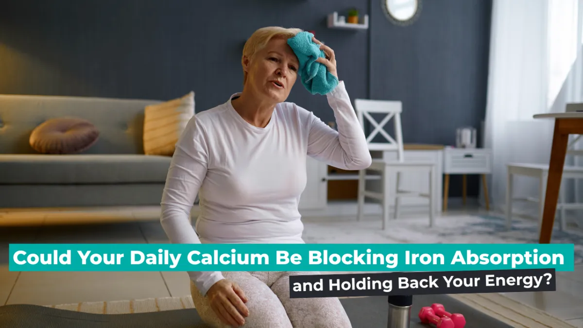 Midlife woman in workout clothes sits on a yoga mat at home, looking fatigued and wiping sweat from her forehead with a towel. Text overlay reads: 'Could Your Daily Calcium Be Blocking Iron Absorption and Holding Back Your Energy?'