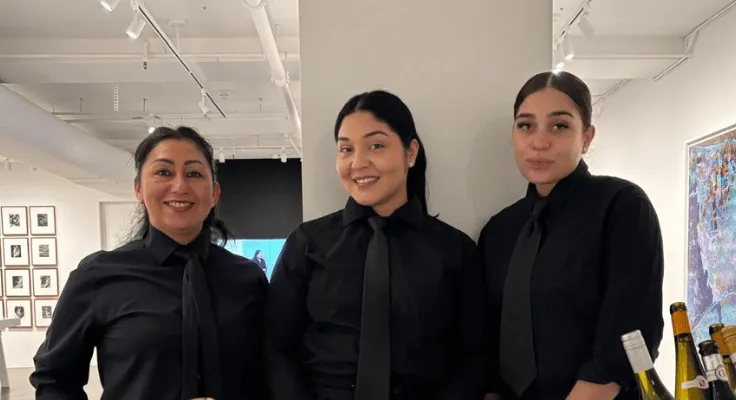 Professional event staff serving champagne during an art gallery event in New York City.