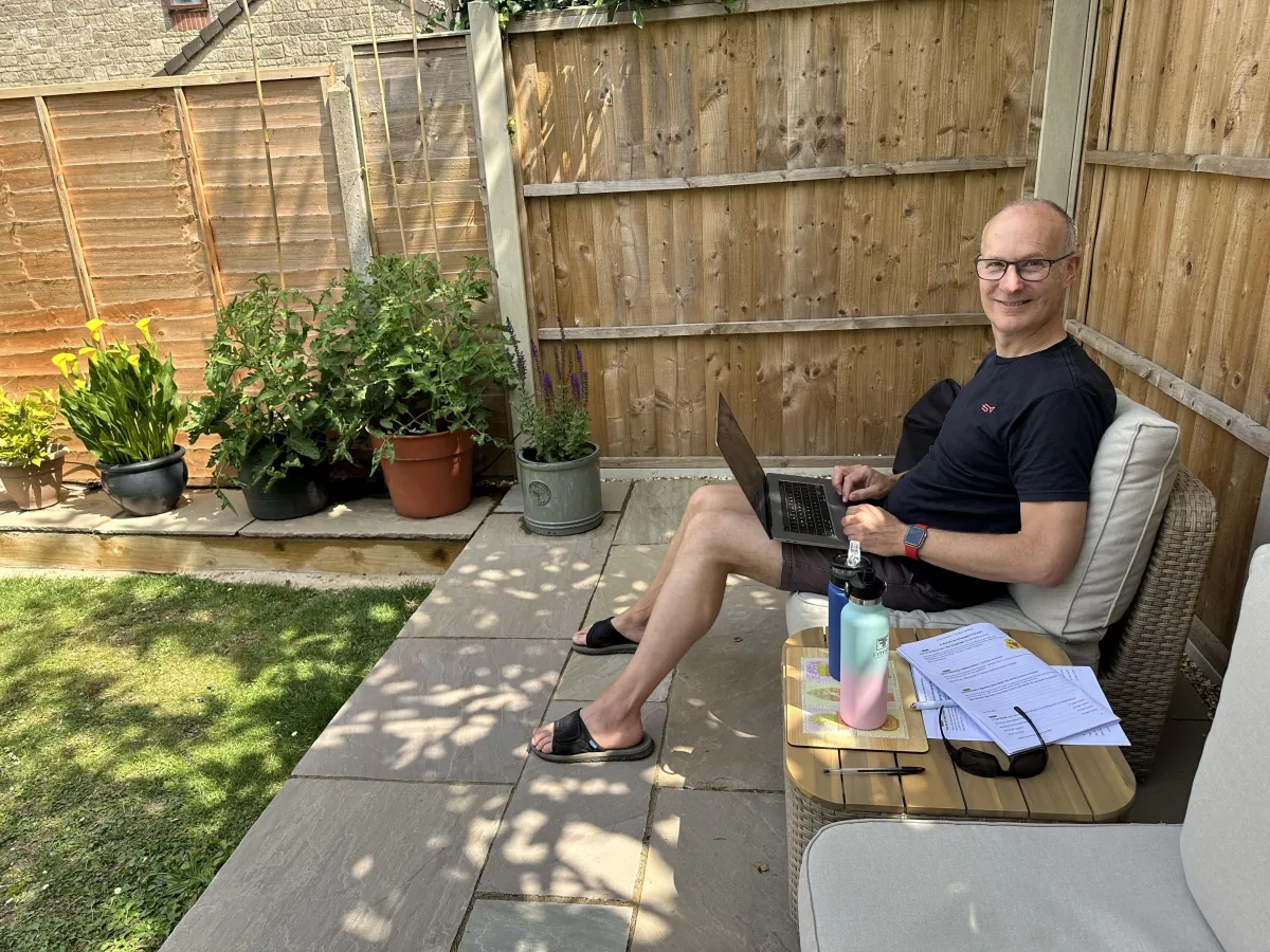 Business coach sat writing a blog in the garden