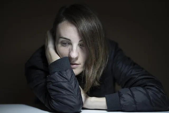 Woman looking fatigued and burntout with head in her hand.