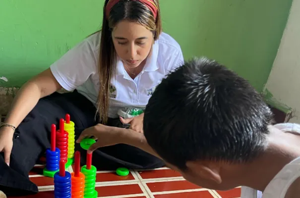 Mujer y niño sonrientes armando juntos un rompecabezas o juego educativo, en un ambiente cálido y colaborativo