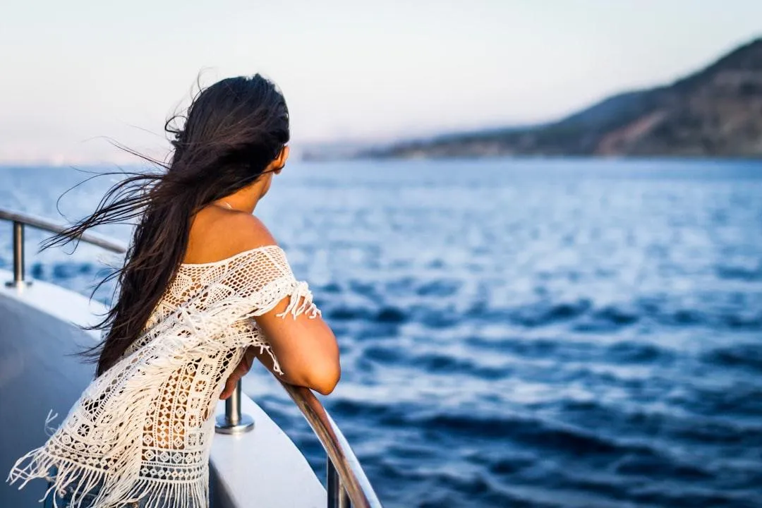 Woman quietly looking at the ocean from a ship