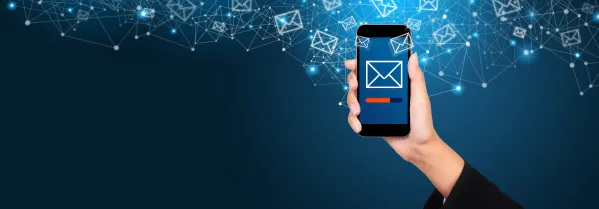 Email marketing and newsletter concept. Sending a message on smartphone screen in businesswoman hand.
