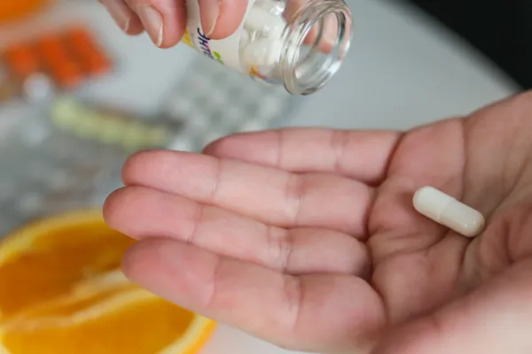 Close-up of a person taking a daily multivitamin supplement for better energy, recovery, and health