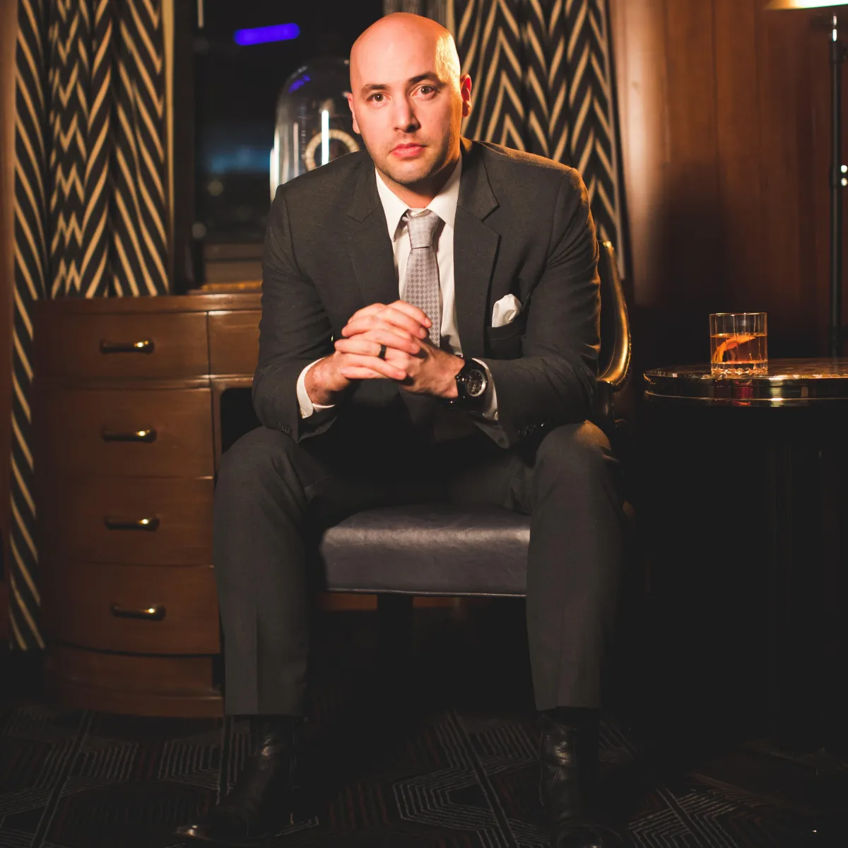 A man in a perfectly fitting bespoke charcoal suit and white dress shirt