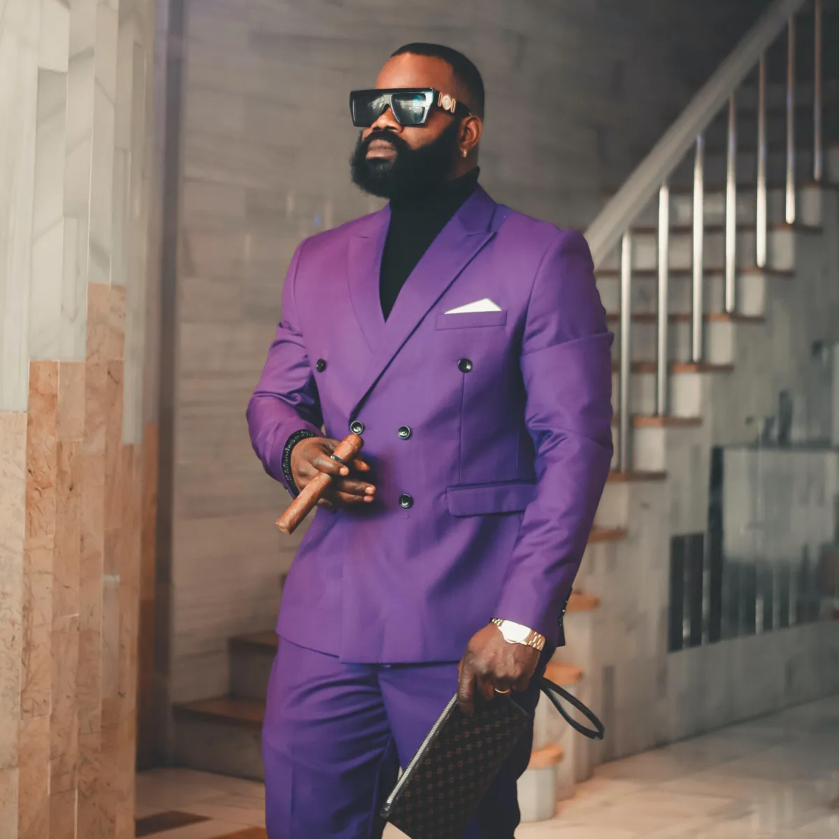 A man wearing a purple suit with a black shirt and a cigar to create his own personal brand