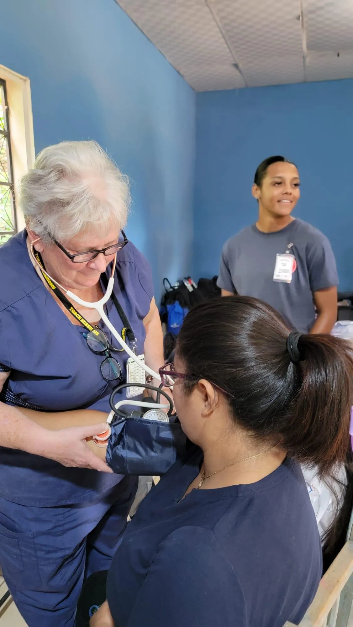 Gayle examines a patient during a Village Clinic.