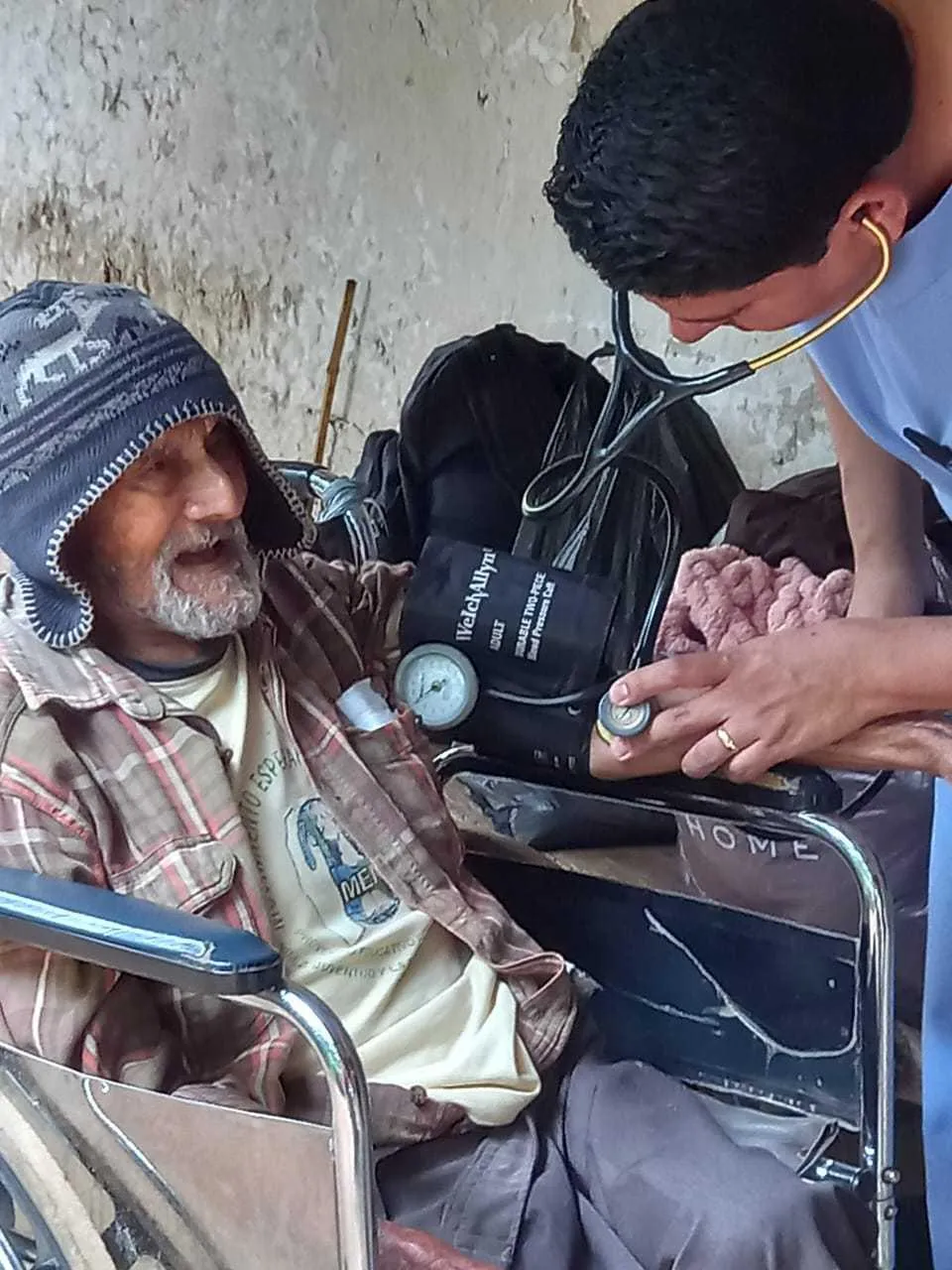 Doctor Jimmy giving medical attention to an elderly man.