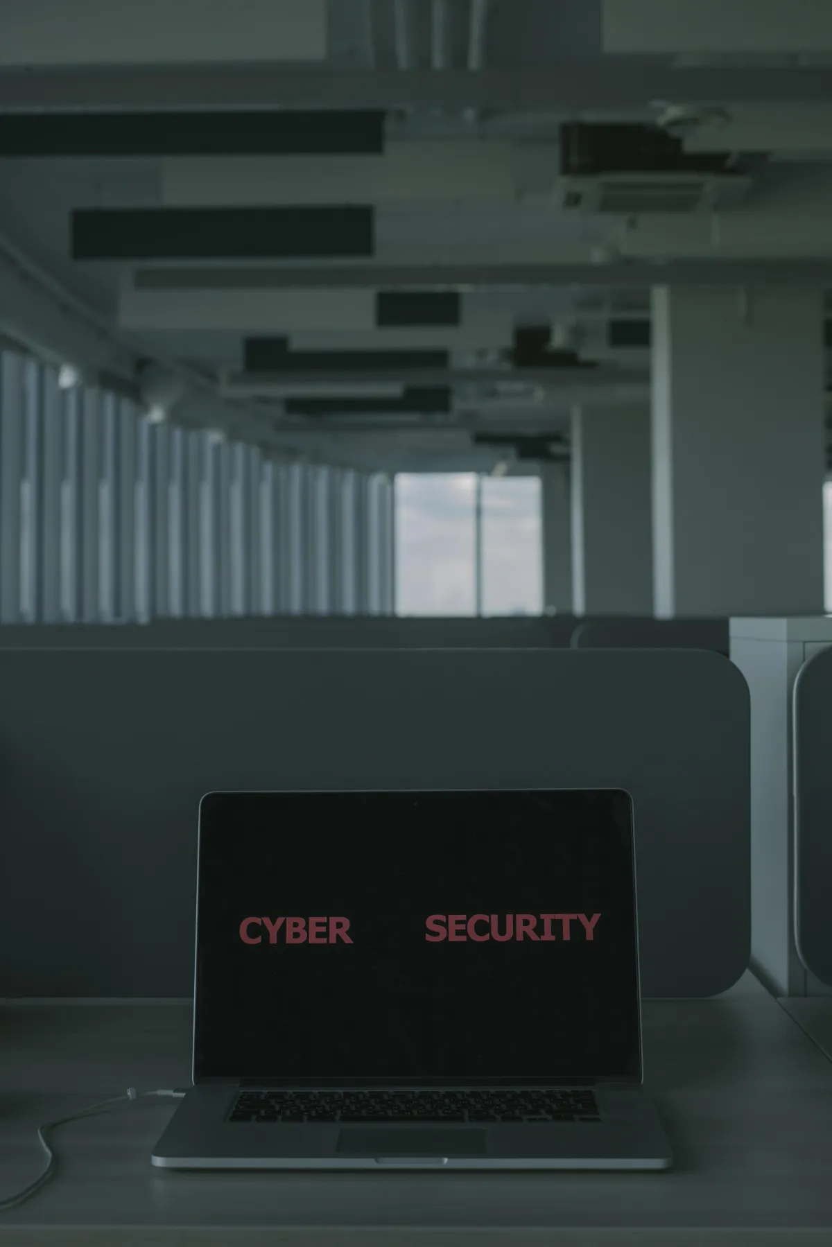 A computer on a desk that displays "CYBER SECURITY" on the screen.