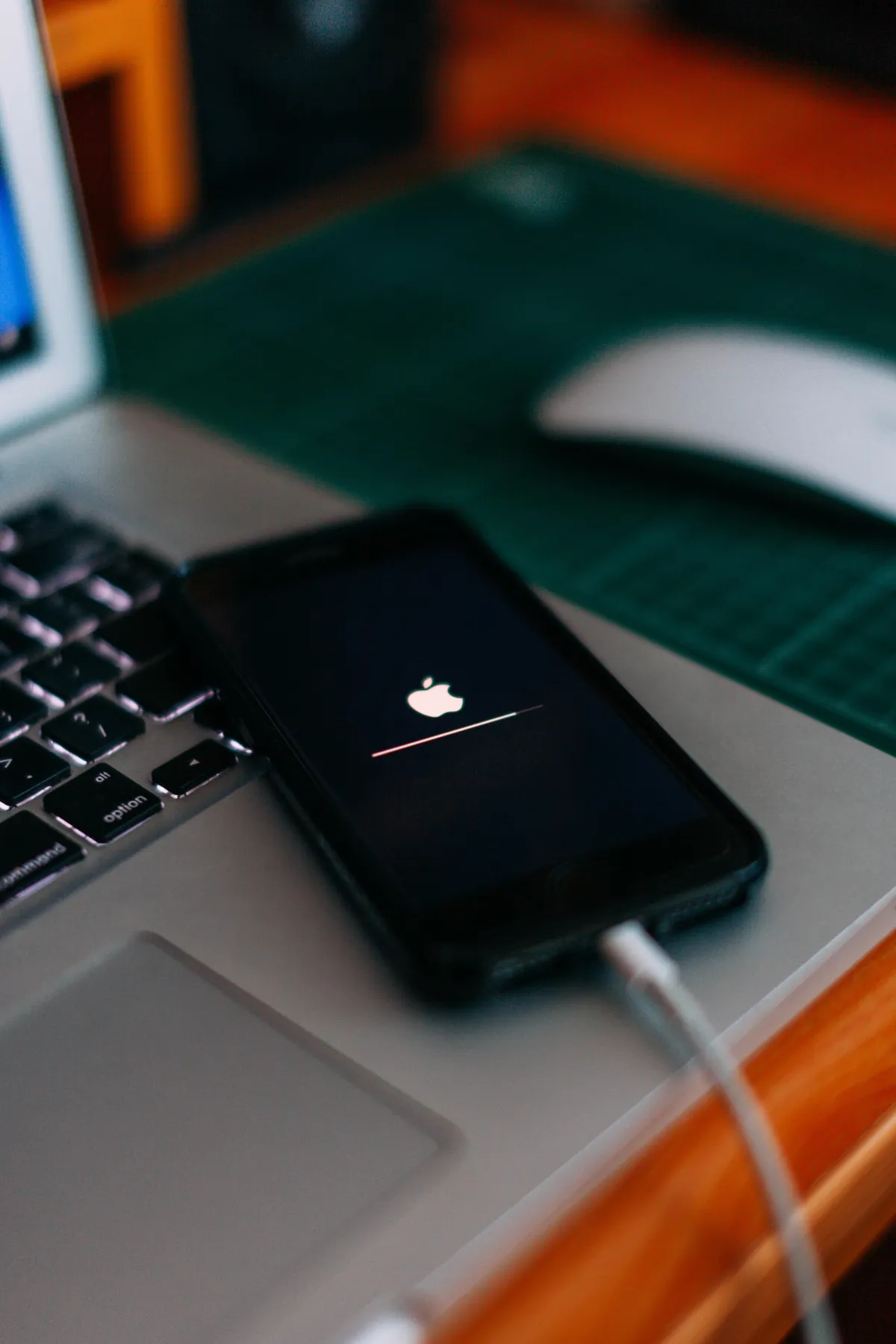 Close up of an iPhone charging whilst sitting on a laptop.