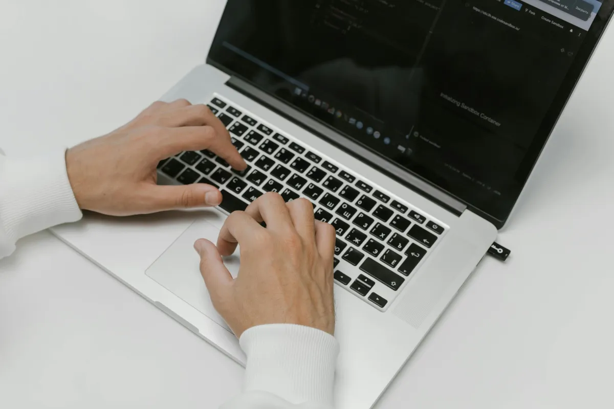 Hands typing on a laptop keyboard.