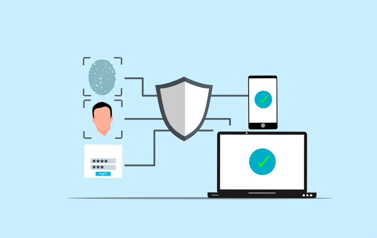 A cartoon image of a shield in the middle of a fingerprint, face, password, a smartphone and a laptop.