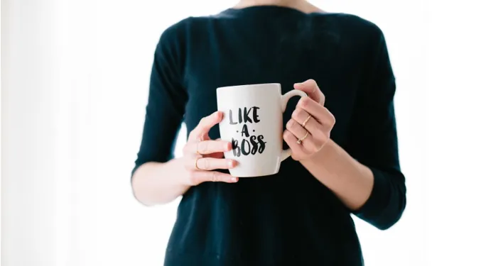 Person holding a white coffee mug that reads ‘Like a Boss,’ symbolizing empowerment, self-awareness, and taking responsibility for success.