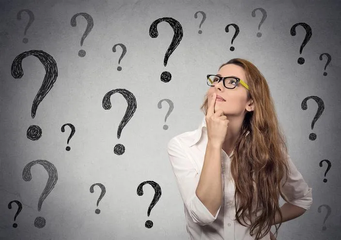 Thoughtful female figure standing in front of a large question mark, representing uncertainty about starting a life coaching business.