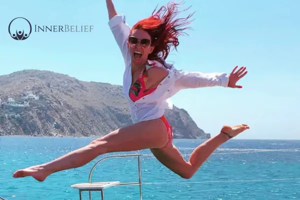 Empowered Peer Impact Partner, Nikki Retigan, radiating confidence and joy while jumping on a boat