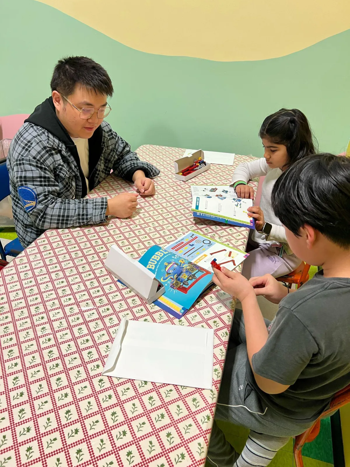 Teacher teaching two students some stem activities