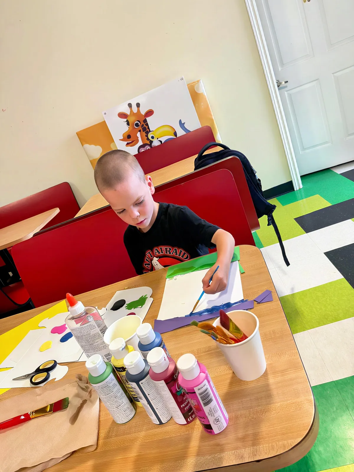 boy dress in black t-shirt doing some art work (Painting)