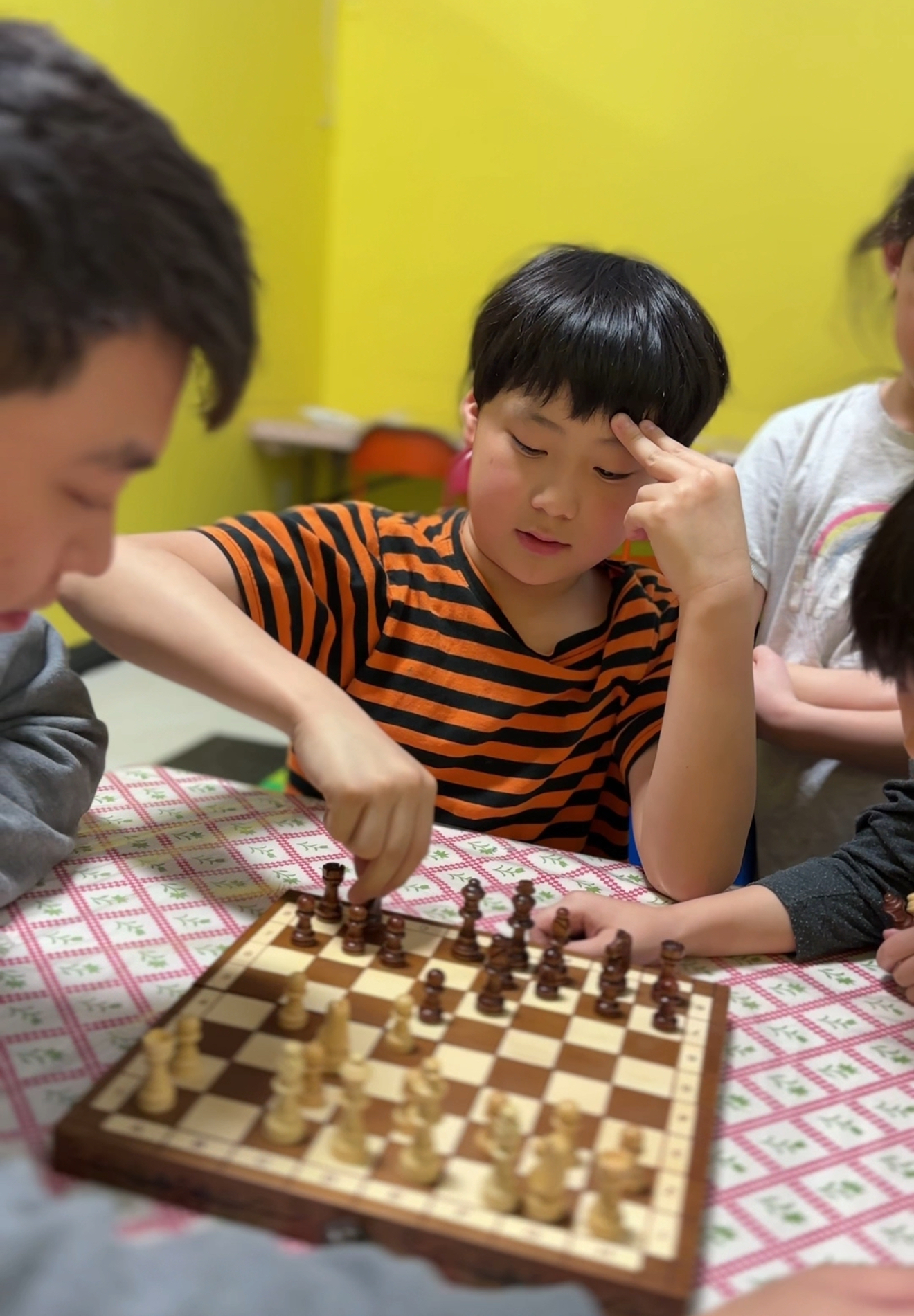 Kid playing chess with tutor