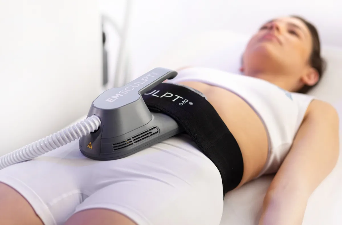 A woman receiving EmSculpt treatment