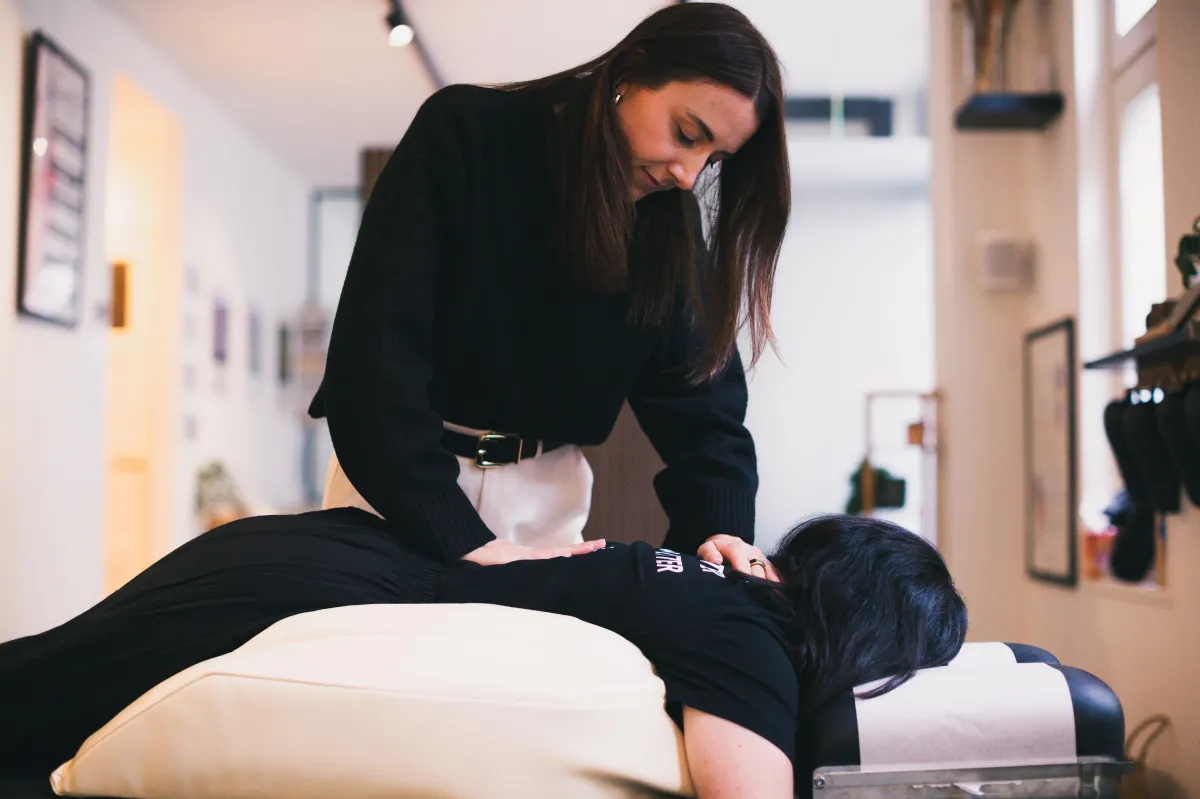 a chiropractor from one chiropractic studio gently adjusting a pregnant woman