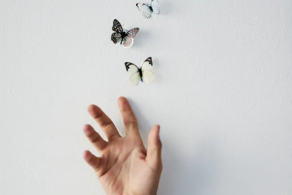 womans hand letting go of butterflies