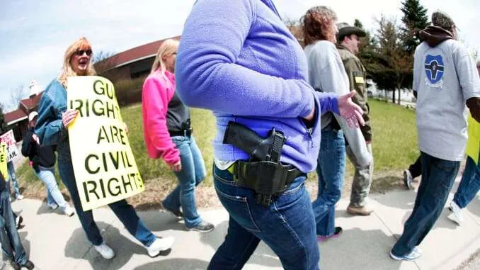 A female demonstrator exercising Open Carry of a firearm.