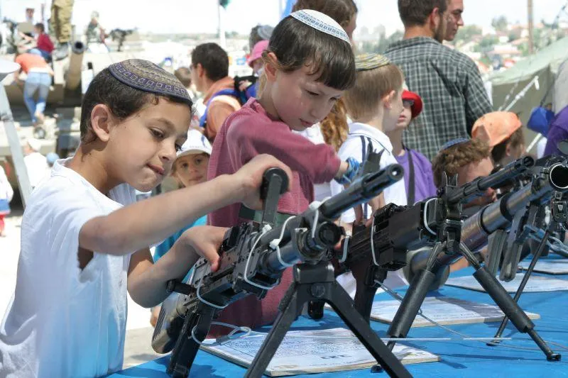 israeli kids tinker with guns on display at a gun show