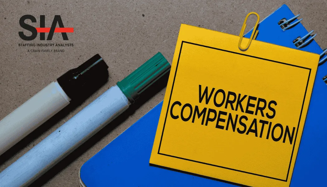Close-up of a yellow notepad labeled “Workers Compensation” clipped to blue notebooks beside black and green markers on a textured desk surface, with the Staffing Industry Analysts (SIA) logo visible—symbolizing workers’ comp insurance, compliance, and risk management in the staffing industry.
