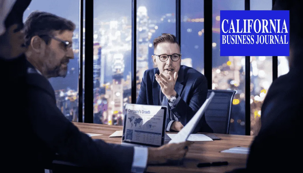 Business executives seated around a conference table reviewing documents during a nighttime meeting, with a city skyline visible through floor-to-ceiling windows and the California Business Journal logo displayed—representing executive decision-making, corporate growth strategy, and California business leadership.