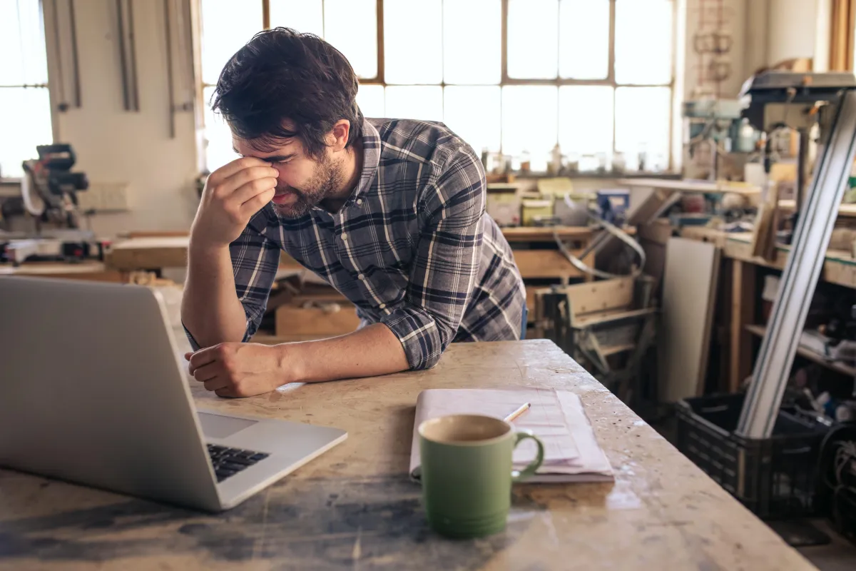 Man overwhelmed with clutter and work on his desk