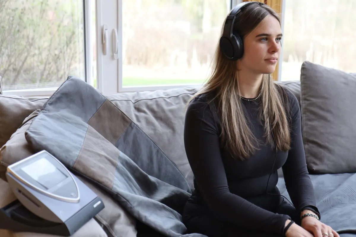 Woman sitting on PEMF mat while listening to meditations