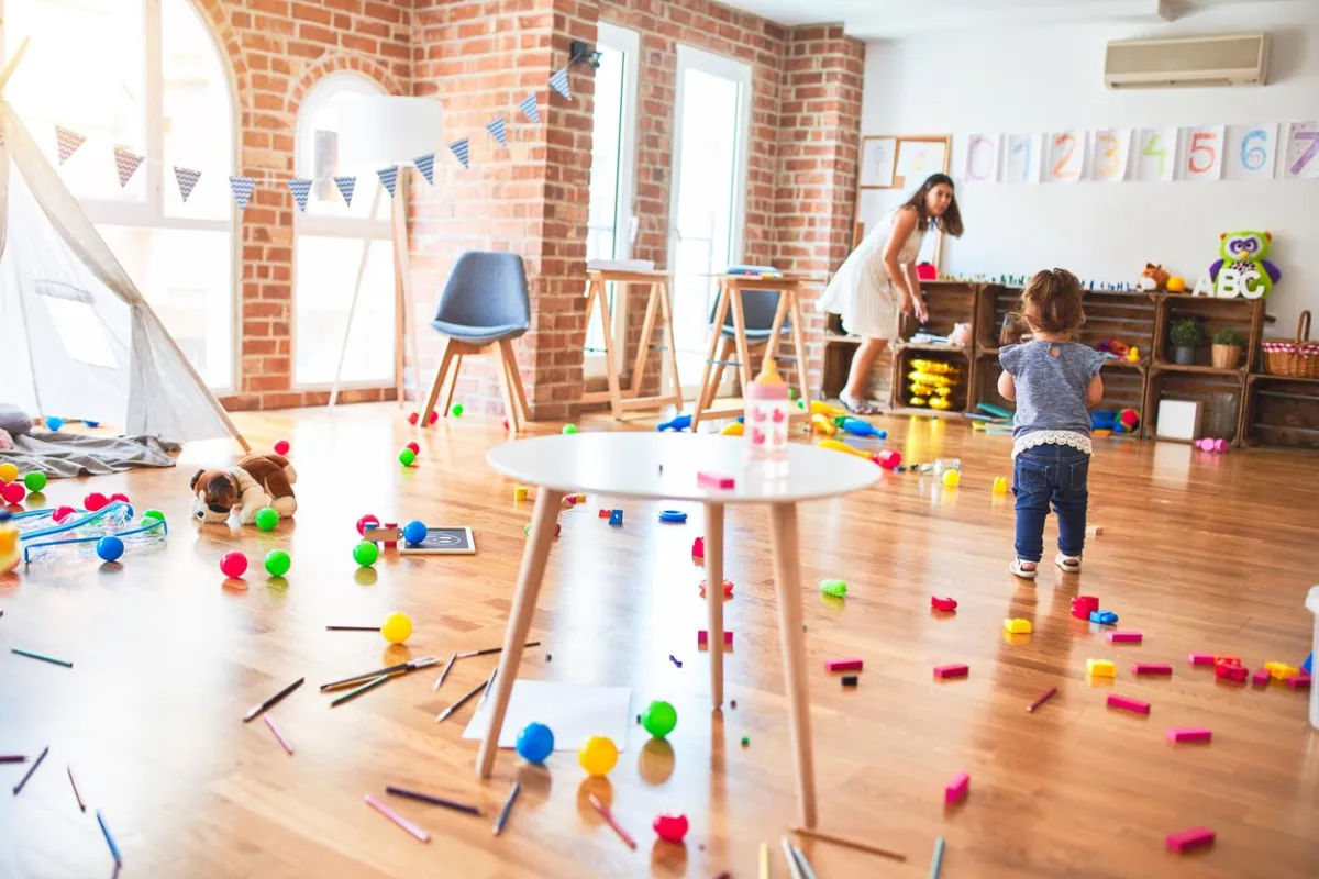Child moving through a room with toys all over the floor