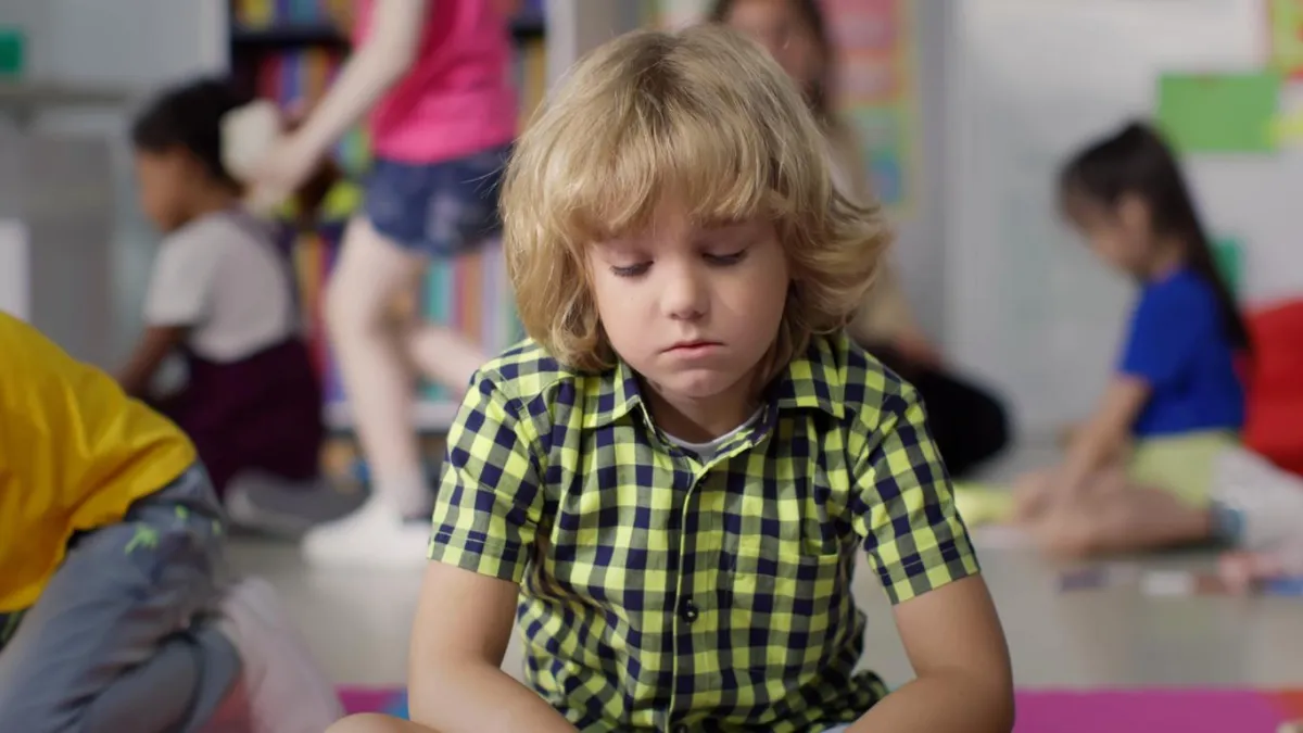 Child sitting on the floor with a dejected look on their face